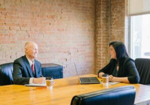 man and woman from antigua and barbuda citizenship by investment law firm sitting at a table