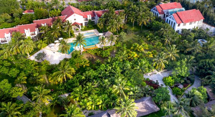 aerial-view-of-antigua-resort-surrounded-by-greenery-and-with-a-pool-in-the-center