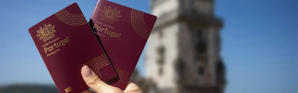 person holding two portuguese passports