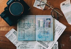 a passport, camera, and glasses on a table