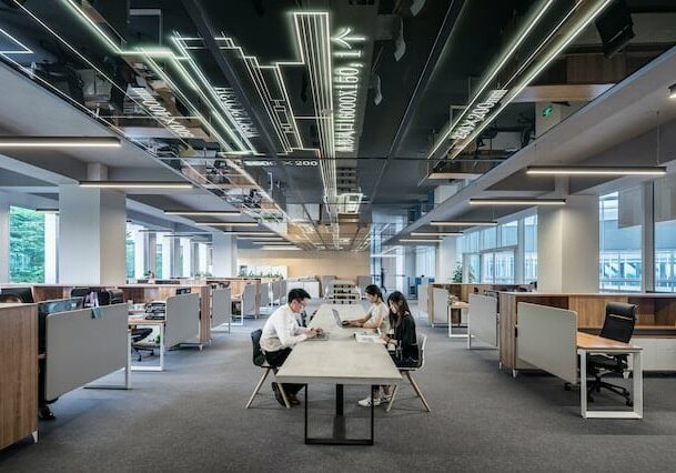 People sitting at a desk in an industrial-style office - Best Citizenship by Investment programs