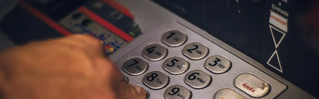 Person entering pin at ATM at a Latvian bank
