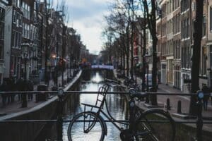 Bicycle on a bridge in Amsterdam, Netherlands, flanked by traditional Dutch houses - ease of doing business in Europe
