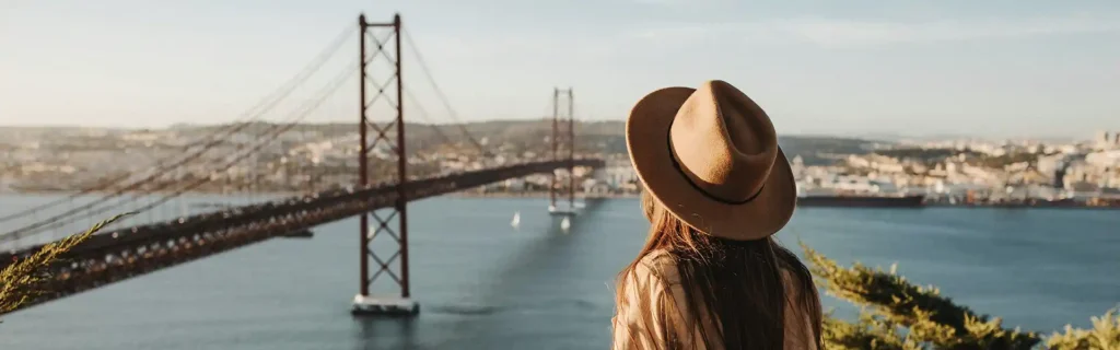woman looking at 25 Abril bridge in Lisbon, Portugal