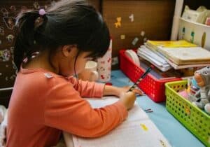 Child sitting at a desk doing homework - second citizenship education benefits