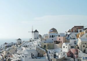 A coastal village in Greece with white houses on a hill overlooking the ocean 