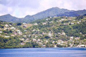 view caribbean island of grenada from the sea with house and mountains in the distance