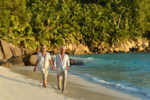 retired couple walking on a caribbean beach