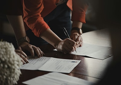 person signing documents on a table for Turkey citizenship by investment