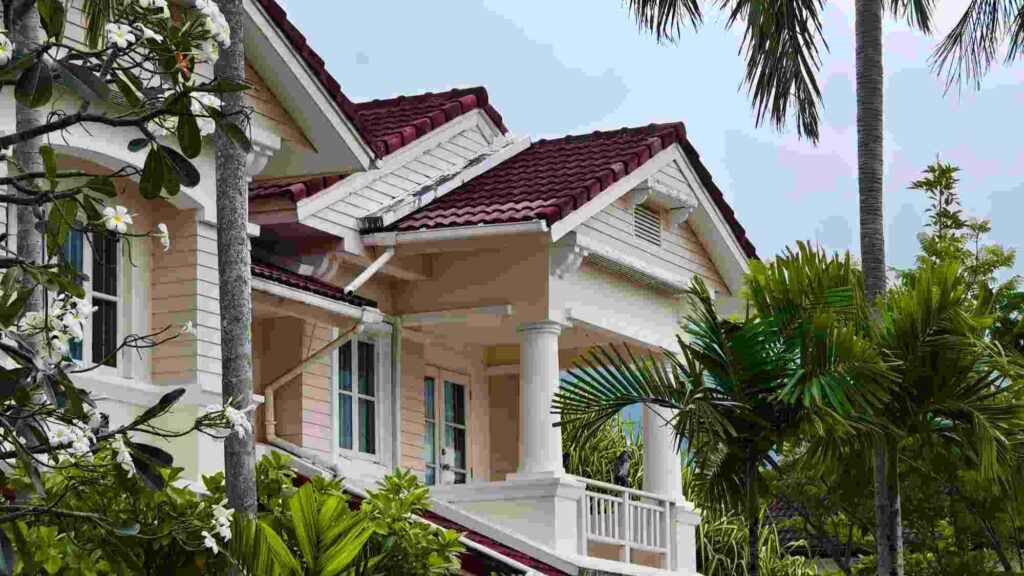 side view of a large caribbean home surrounded by trees
