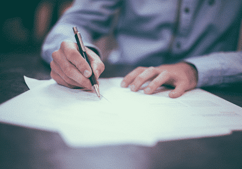 Man signing a document - countries with no income tax