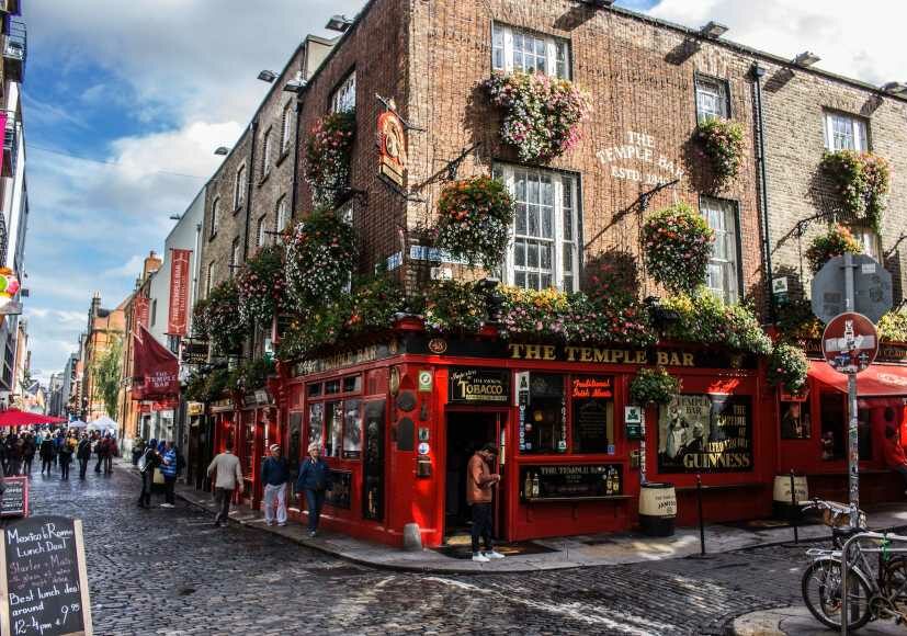 The iconic Temple Bar in Dublin, Ireland with people walking on the street - Ireland low-tax country