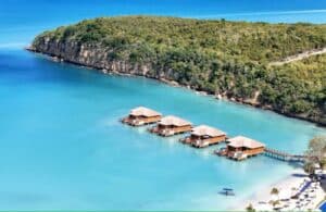 Resort cottages in the ocean in Antigua and Barbuda's bright blue water - islands countries that are tax-free