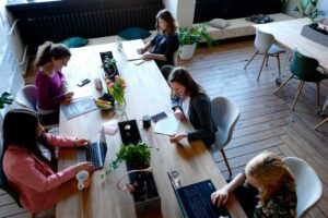 Remote workers in Portugal sharing a desk at a co-working space.