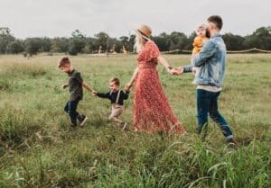 Family of five walking through a green field after moving to Serbia