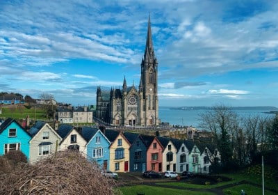 Colorful row of houses in front of a cathedral in Ireland - Ireland Start-up Entrepreneur Programme (STEP visa)