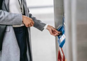 Woman in a gray coat using her card at an ATM - opening an international bank account