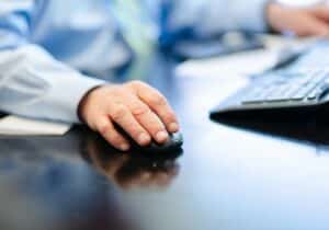 Man using a mouse and a keyboard at a desk - The World's Best Banks