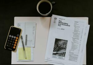 tax documents, a phone, and coffee on a table