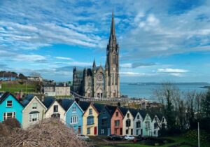 Colorful row of houses in front of a cathedral in Ireland - English-speaking nations for expats to work and live in