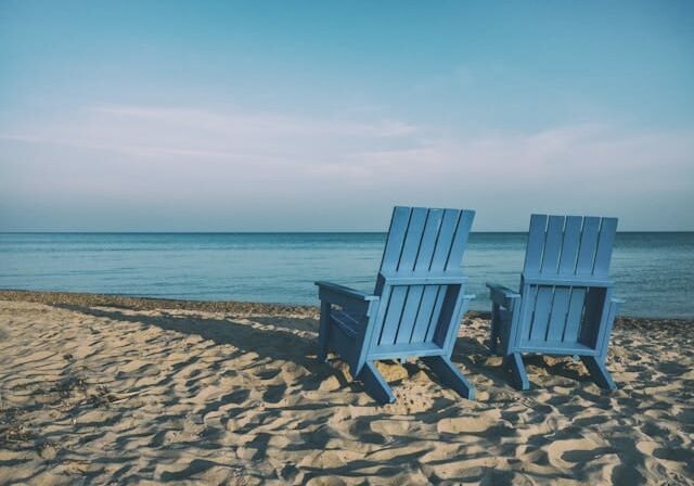 Blue beach chairs overlooking the ocean - benefits of retirement near the beach