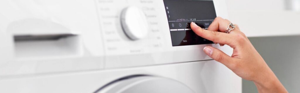 person dialing a washing machine at home
