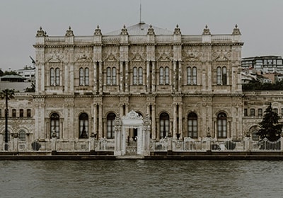 Front view of the ornate Dolmabahçe Palace in Istanbul, Turkey, as seen from the Bosphorus waterfront, showcasing its grand neoclassical architecture and detailed façade.
