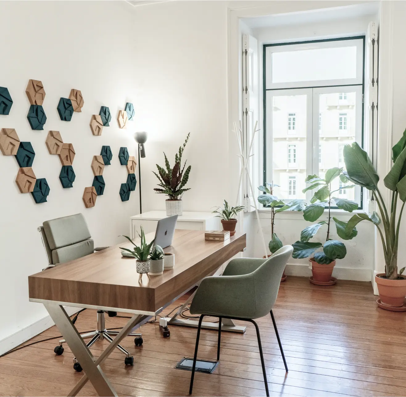 A cozy home office featuring a desk, chair, and several green plants for a refreshing atmosphere.