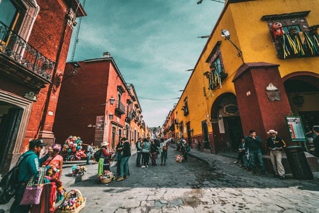 Street in Mexico lined with orange buildings - best countries to move to from USA