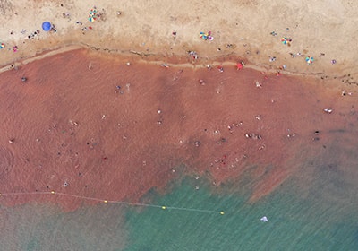 Aerial view of a aquamarine blue and brown shoreline in Paraguay - best retirement places