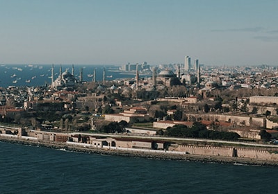 Aerial view of Istanbul’s historic peninsula, featuring the Hagia Sophia, Blue Mosque, and the Sea of Marmara with numerous ships in the distance.