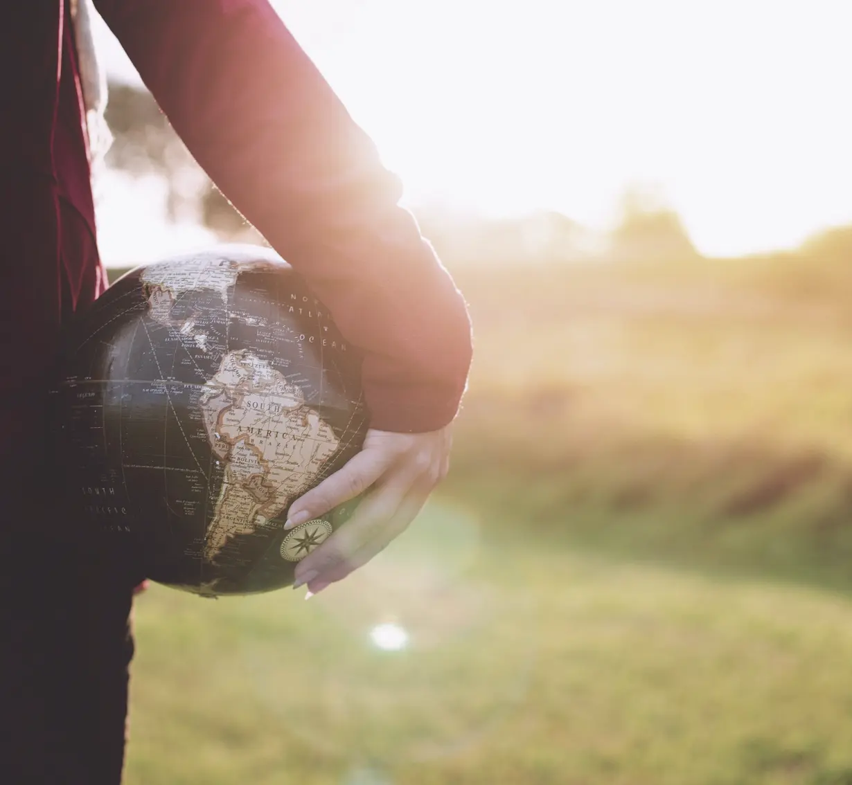 A person holding a globe in their hand, symbolizing global awareness and connection.