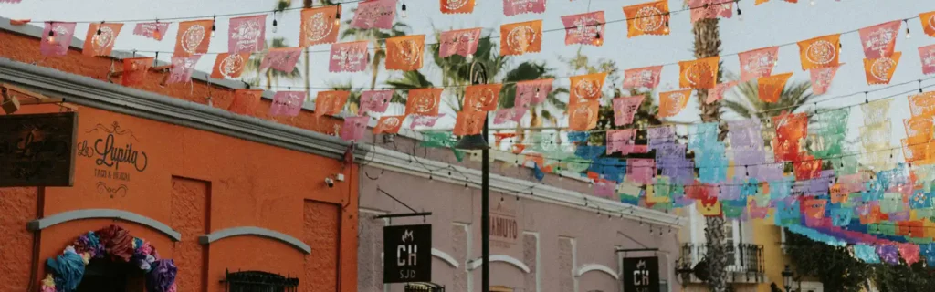 Mexican celebration flags hanging between buildings in Mexico - happiest countries in the world