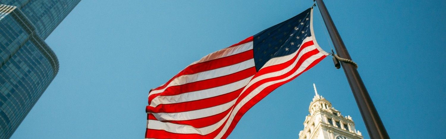 a us flag waving in front of buildings